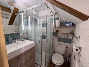 Ein Badezimmer mit Dusche, Toilette und Waschbecken.