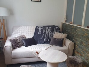 Ein Wohnzimmer mit einer Couch, einem runden Couchtisch und einer Lampe.