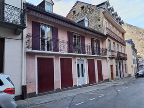 A row of buildings with balconies, a street, and parked cars. - Apartment with Balcony and Wi-Fi in Cauterets Center (Cauterets)
