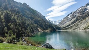 A mountain lake with clear water, surrounded by forested hills and a clear sky. - Apartment with Balcony and Wi-Fi in Cauterets Center (Cauterets)