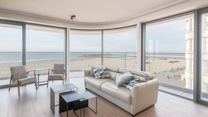 Una sala de estar moderna con un ventanal que da a una playa.