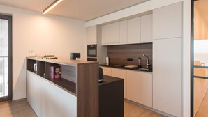 Una cocina moderna con una isla central, electrodomésticos integrados y un diseño minimalista.