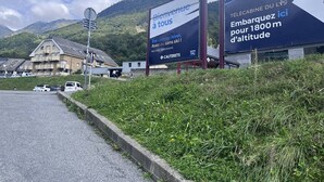 A mountain resort with a sign welcoming visitors and advertising a cable car service to 1800 meters altitude.