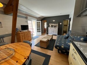 Relax in this inviting living space with a dining table, sofa, and kitchen area.