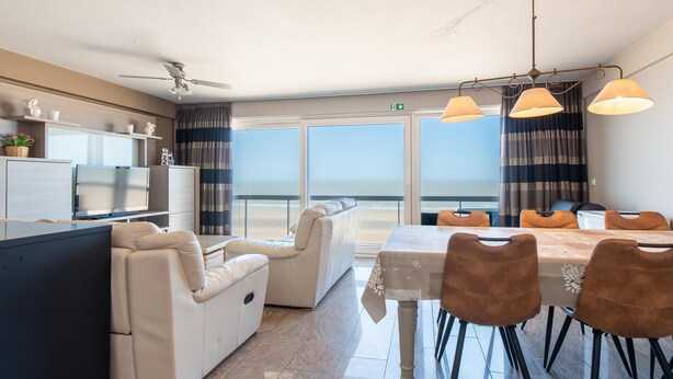 A modern hotel room with a balcony, a dining area, and a living space. - Apartment With a top Location in Mariakerke (Ostend)