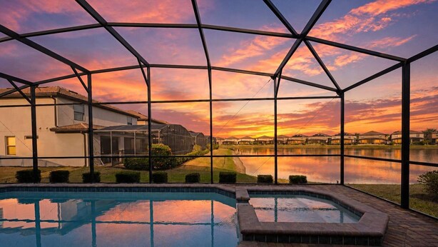 Una piscina con vistas a un atardecer sobre una masa de agua, rodeada por una zona techada con estructura metálica.