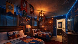 Una habitación con dos camas, una estantería y un escritorio con ordenador.