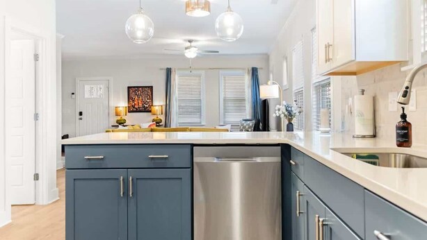 A modern kitchen with a dishwasher, stainless steel appliances, and pendant lighting. - Family-Friendly 4BR w/ Fenced Yard & Parking (Durham)