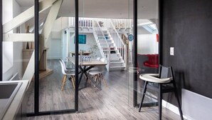 A modern interior with a dining area, a staircase, and a red sofa. - Artists' Loft (Sainte-Savine)