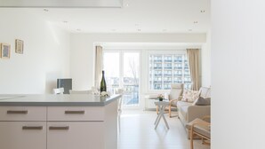 Un appartement moderne comprenant une cuisine, un coin repas et un salon.