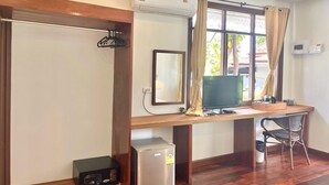 A room with a wooden desk, a television, a small refrigerator, and a chair. - Sea Beach at Lipe (Koh Lipe)