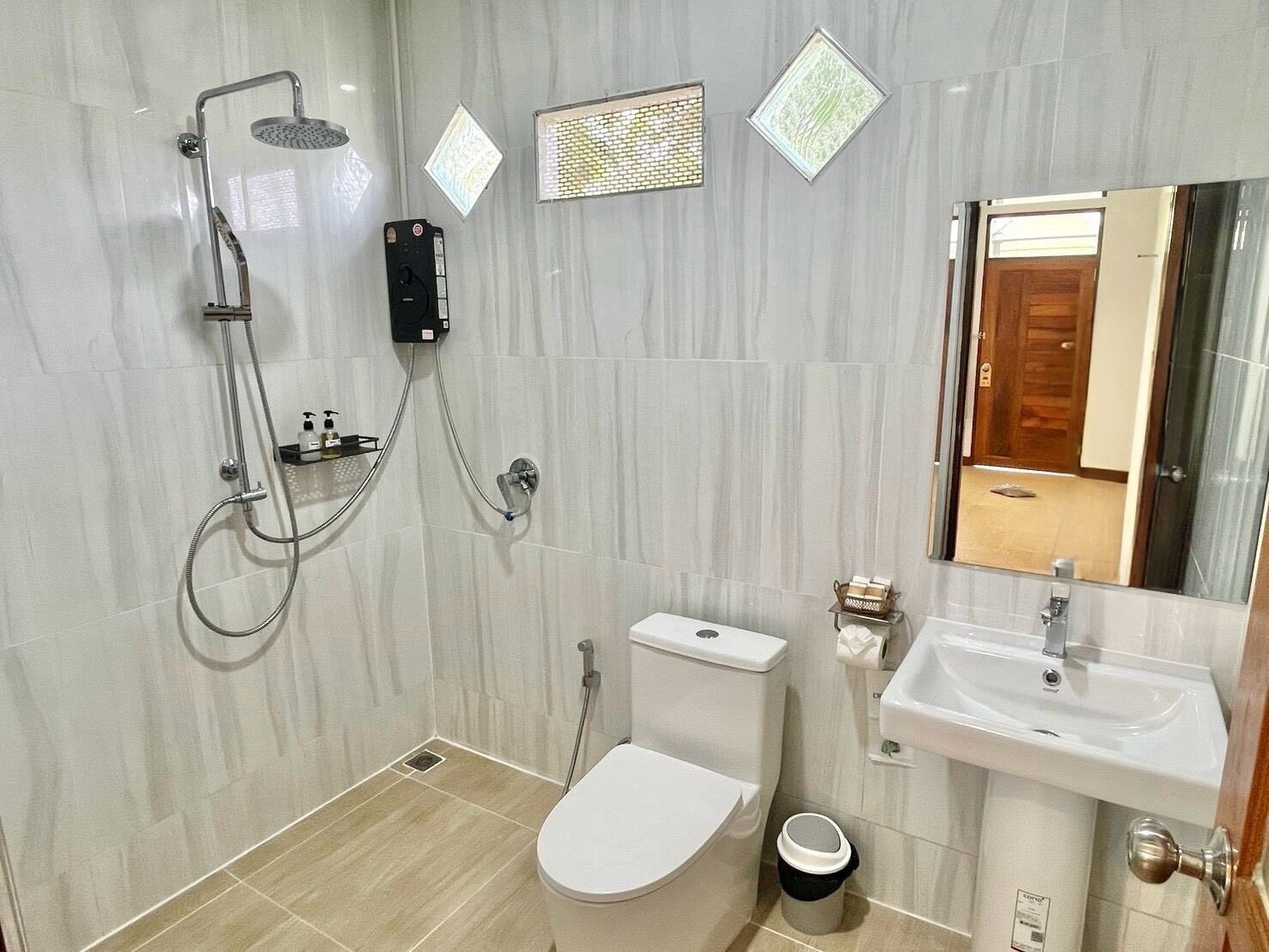 A modern bathroom with a toilet, bidet, and shower unit.