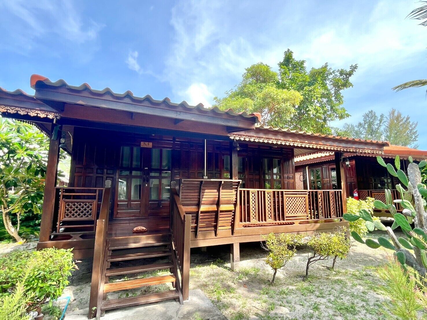 A wooden structure with a covered porch and a staircase leading to the entrance.