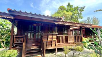 A wooden structure with a covered porch and a staircase leading to the entrance.