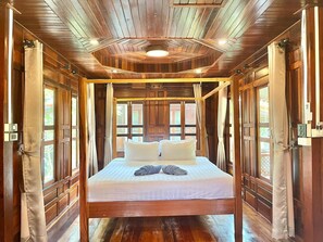 Une pièce en bois avec un lit, des rideaux et une fenêtre.