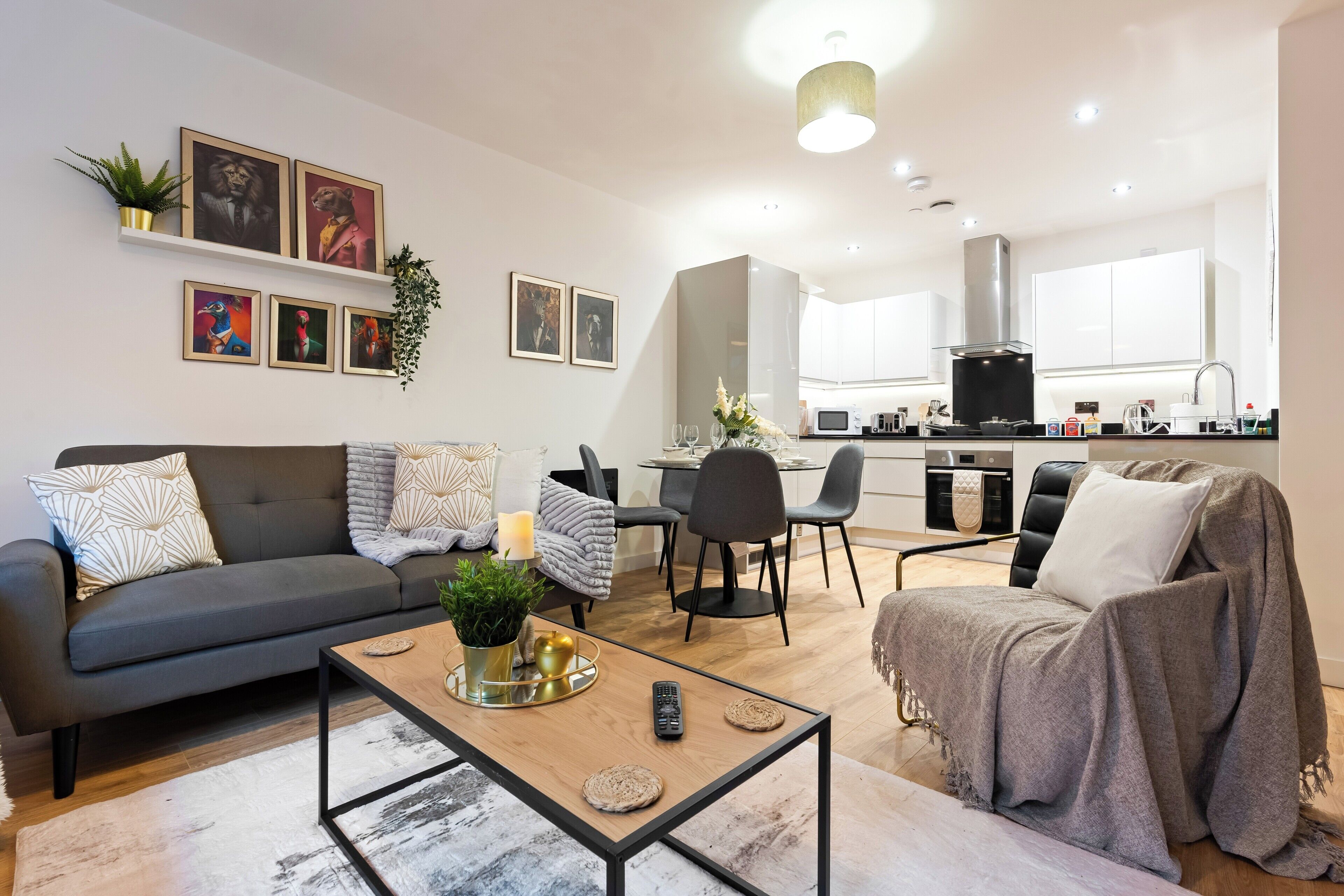 A modern living room with a sofa, coffee table, and a dining area.