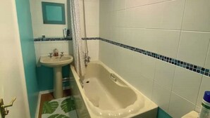 A bathroom with a bathtub, sink, and shower. - Cosy 1 Bedroom Apartment Private Access in Guildford

 (Guildford)