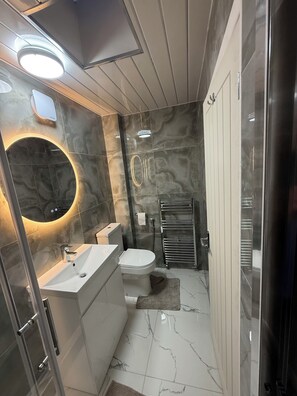 A modern bathroom with a glass-enclosed shower, a white sink, and a toilet. - Cosy 1 Bedroom Apartment Private Access in Guildford
(Guildford)