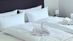 A neatly made bed with white linens and a folded towel on the side. - Sanosueno 5 - Bergblick Deluxe (Sonthofen)