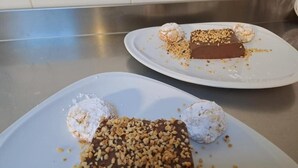 Twee vierkante borden met desserts op een aanrecht van roestvrij staal.