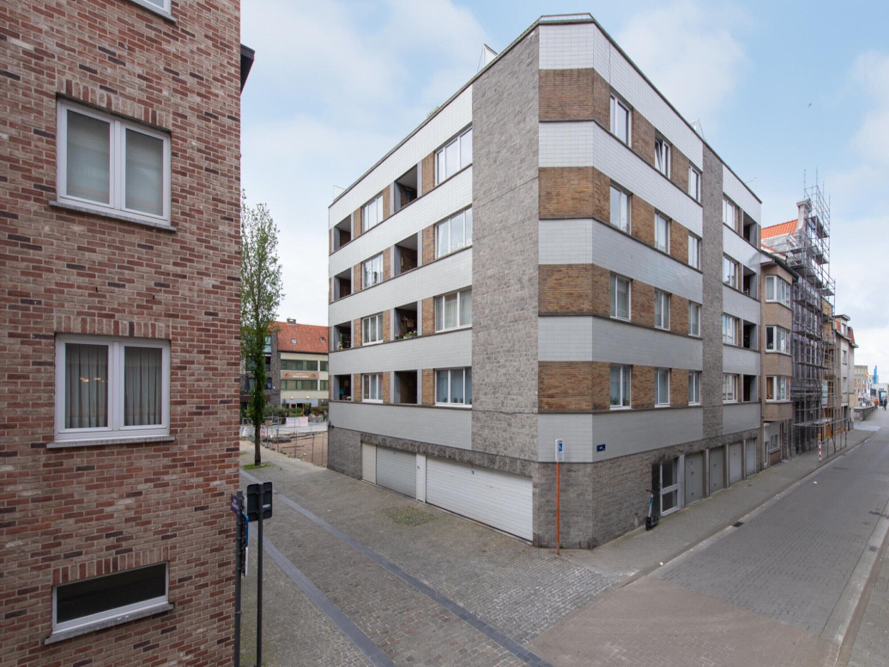 A multi-story residential building with a brick facade and a modern design.