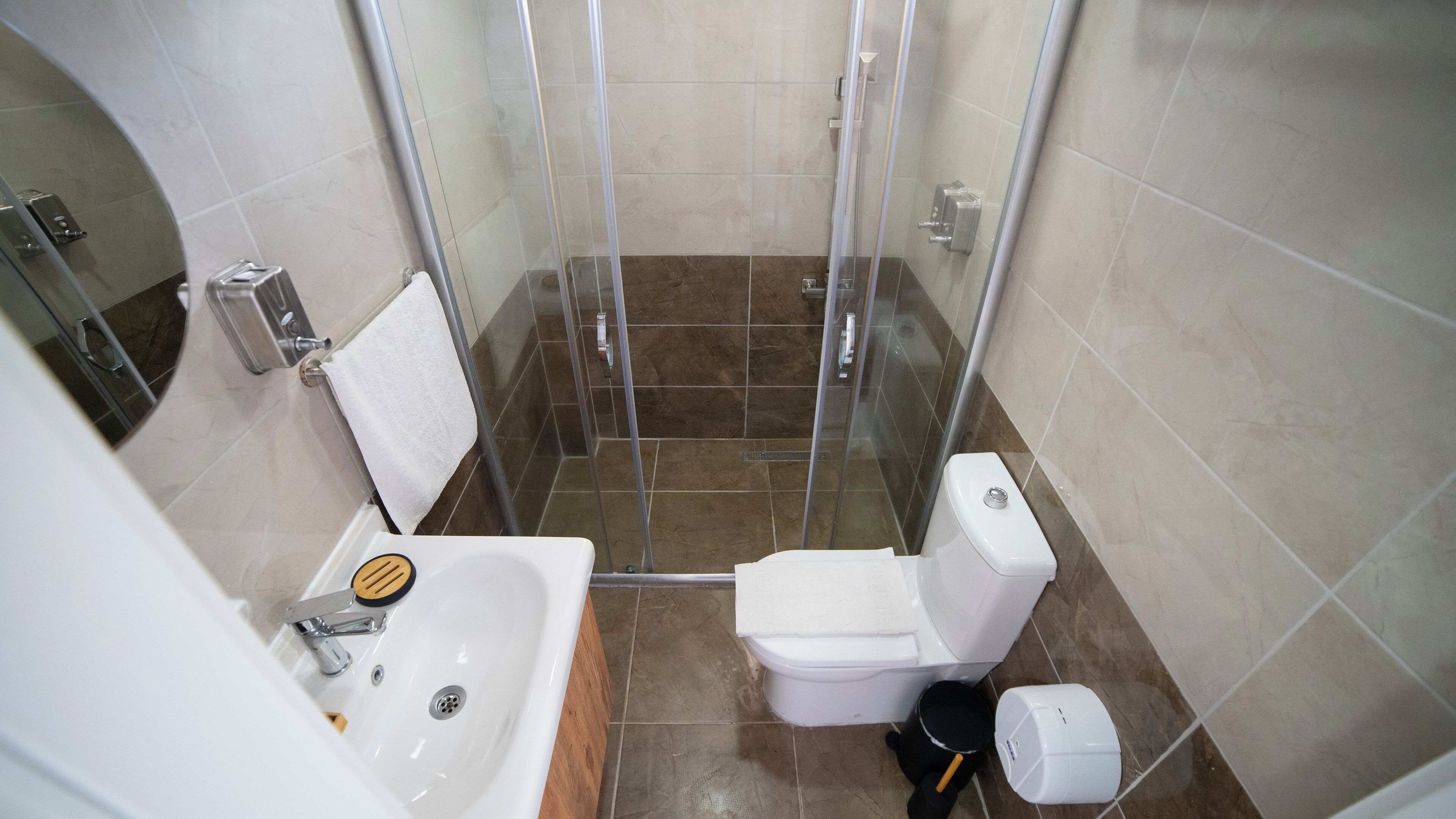 Un baño pequeño con ducha, inodoro y lavamanos.