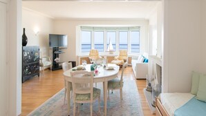 A spacious room with a dining area, a sofa, a bed, and a view of the sea. - Studio With sea View in Ostend (Ostend)