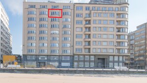 A multi-story hotel with a modern architectural design, featuring a prominent entrance and a series of balconies. - Studio With sea View in Ostend (Ostend)