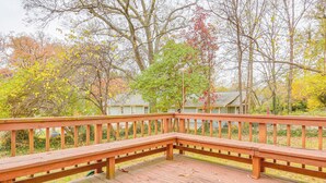 A wooden deck with a bench, surrounded by trees with autumn foliage. - Walk Downtown: Takoma Park Escape w/ Large Yard! (Takoma Park)