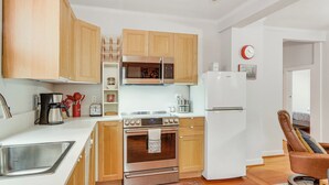 A modern kitchen with wooden cabinets, stainless steel appliances, and a built-in microwave. - Walk Downtown: Takoma Park Escape w/ Large Yard! (Takoma Park)