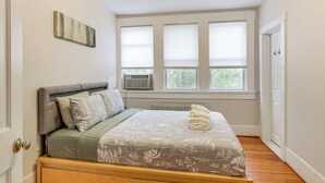 A bedroom with a bed, a radiator, and a window with blinds. - Walk Downtown: Takoma Park Escape w/ Large Yard! (Takoma Park)