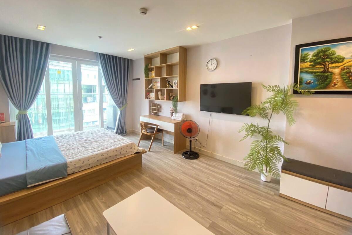 Une chambre d’hôtel moderne équipée d’un lit, d’un bureau, d’une télévision et d’une bibliothèque.