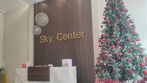 Ein Empfangsbereich mit einem 'Sky Center'-Schild, einem Weihnachtsbaum und Geschenkkartons.