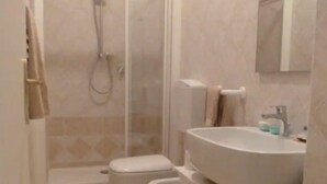 Un baño con ducha, inodoro y lavabo.