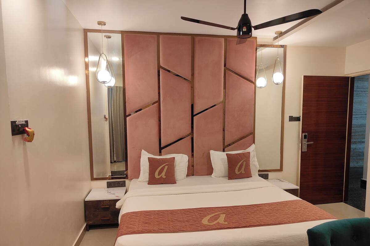 A modern bedroom with a bed, a ceiling fan, a nightstand, and a door.
