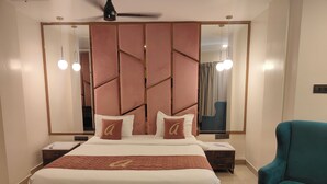 Ein modernes Schlafzimmer mit einem großen Bett, zwei Nachttischen, einem Deckenventilator und einem Türkis-Sessel.