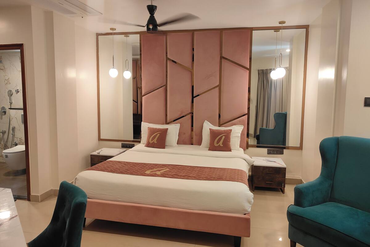 A modern bedroom with a large bed, a ceiling fan, and a mirror.
