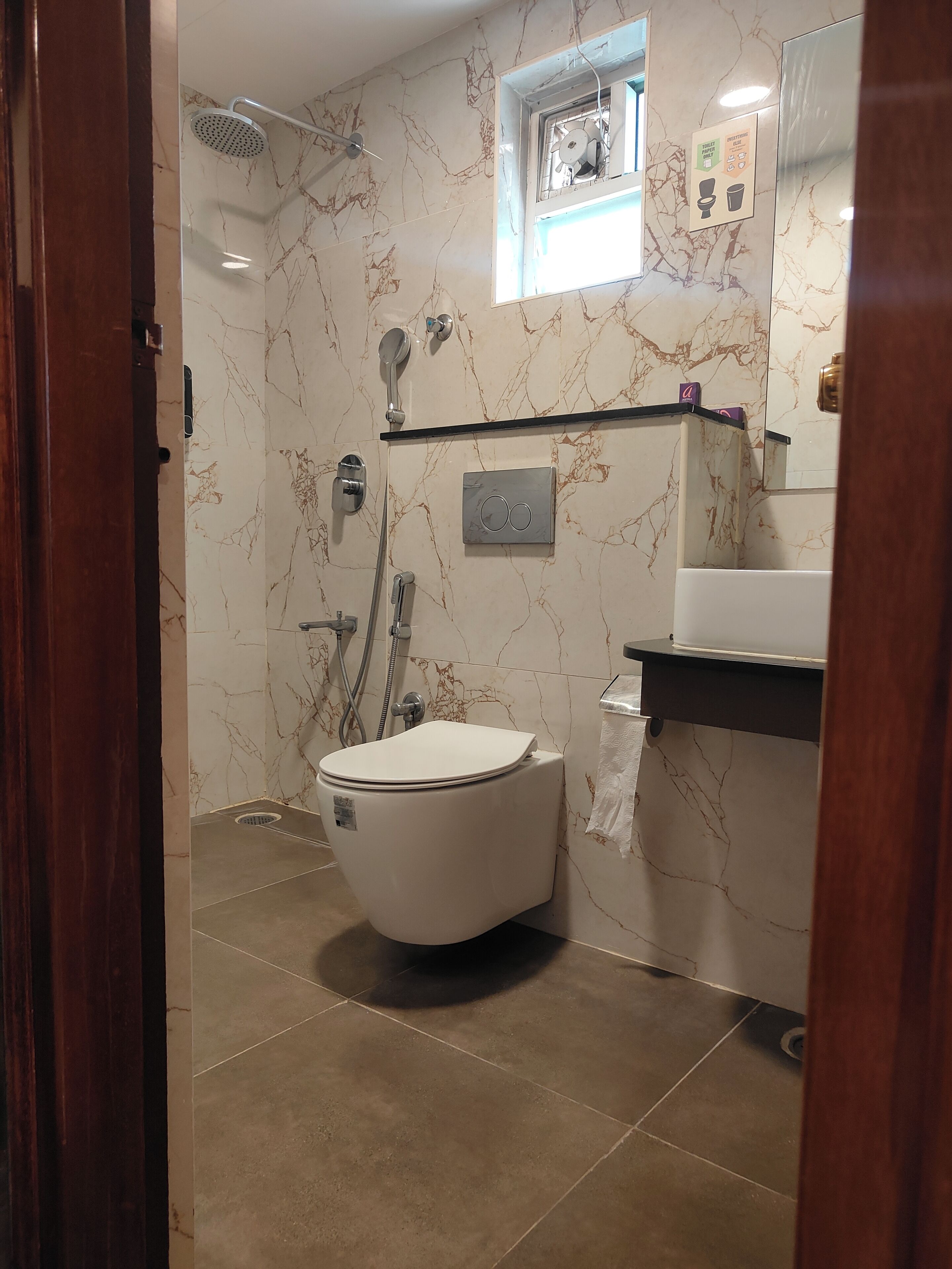 A bathroom with a toilet, shower, and sink.