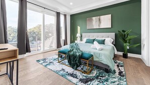A modern bedroom with a large bed, a desk, and a view of the outdoors. - Luxurious 3 Bed3 Bath Near Downtown Houston (Houston)