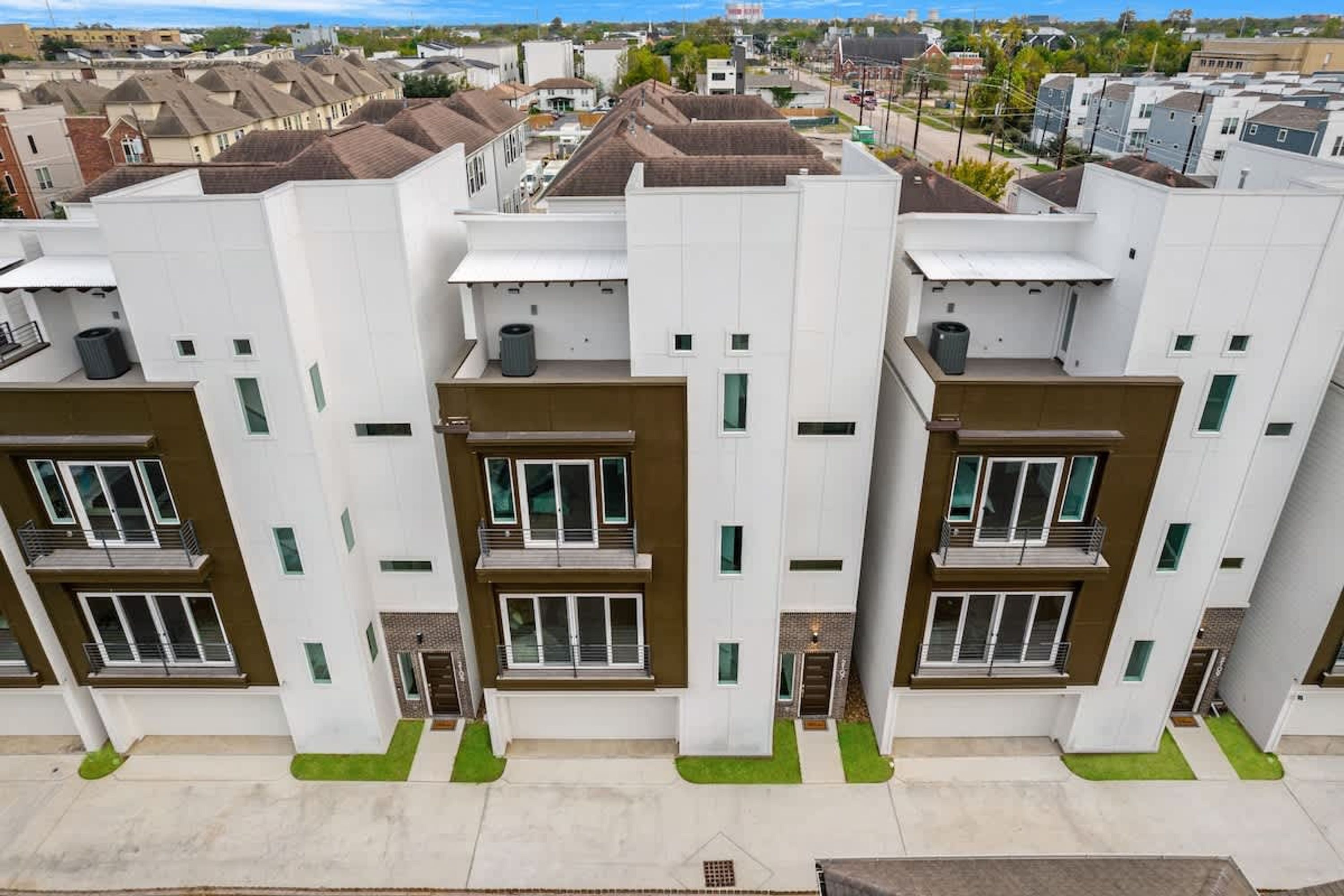A modern apartment building with multiple balconies, a flat roof, and a uniform facade.