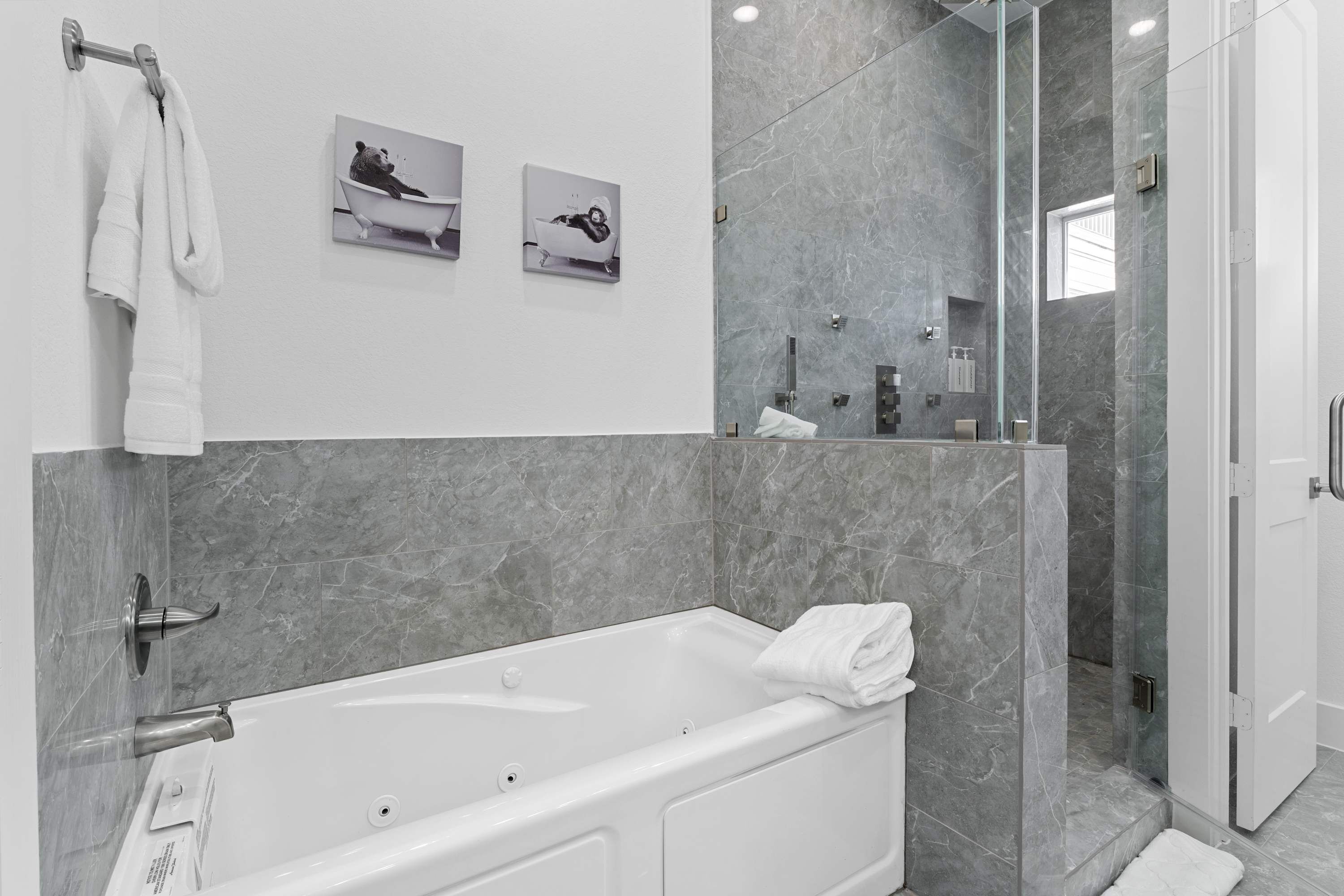 A modern bathroom with a bathtub, a shower, and a glass-enclosed shower area.
