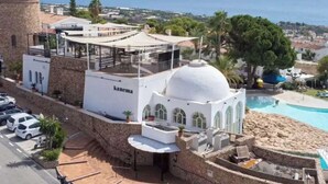 Ein Hotel an der Küste mit Pool, ein weißes Gebäude mit Kuppel und Blick aufs Meer.