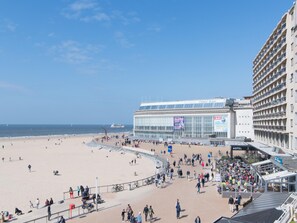 A hotel with a large glass facade, a beach in the foreground, and a clear sky. - Apartment in Ostend With Stunning Sea View (Ostend)