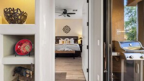 A bedroom with a bed, a ceiling fan, and a decorative wall piece.
