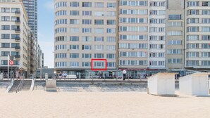 A multi-story residential building with a curved facade, large windows, and balconies. - Frontal sea View Studio Apartment in Ostend (Ostend)