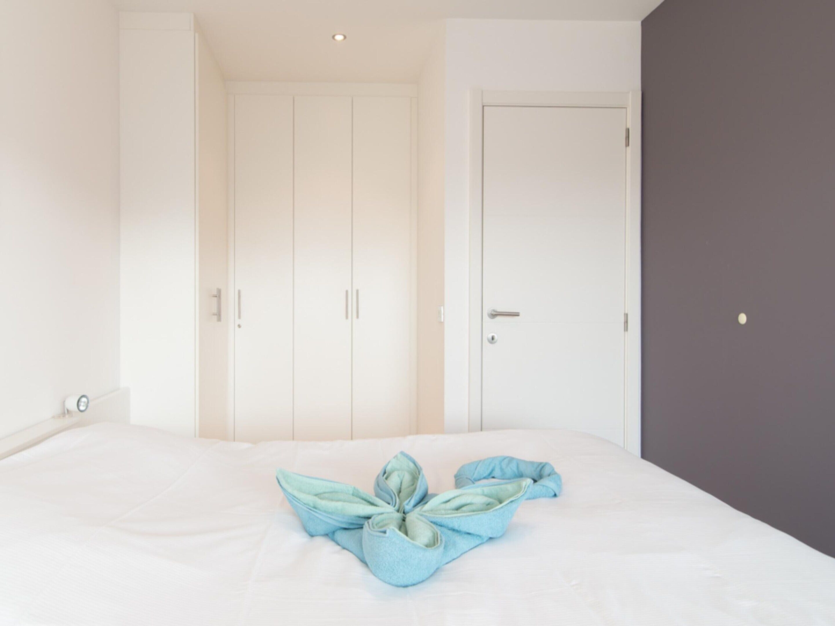 Une chambre à coucher avec un lit, une armoire et une porte.