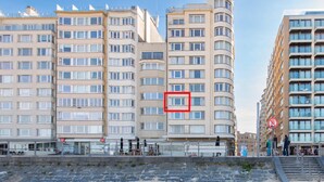 En kystbygning med flere etager, balkoner og en buet facade.