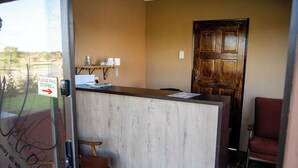 A reception desk with a wooden door, a small seating area, and a welcome sign.