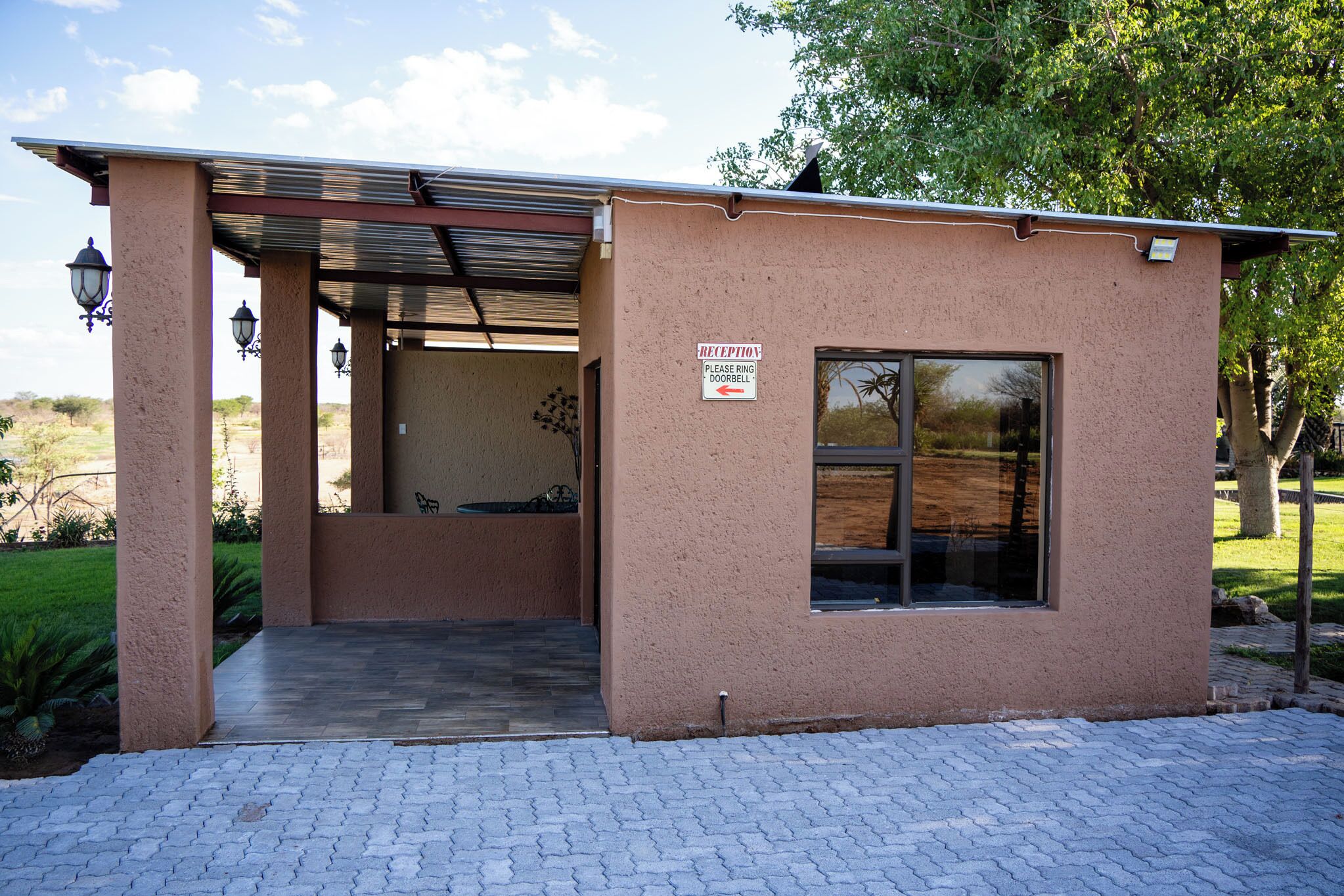 A reception area with a sign instructing to ring the doorbell, a covered entrance, and a window.