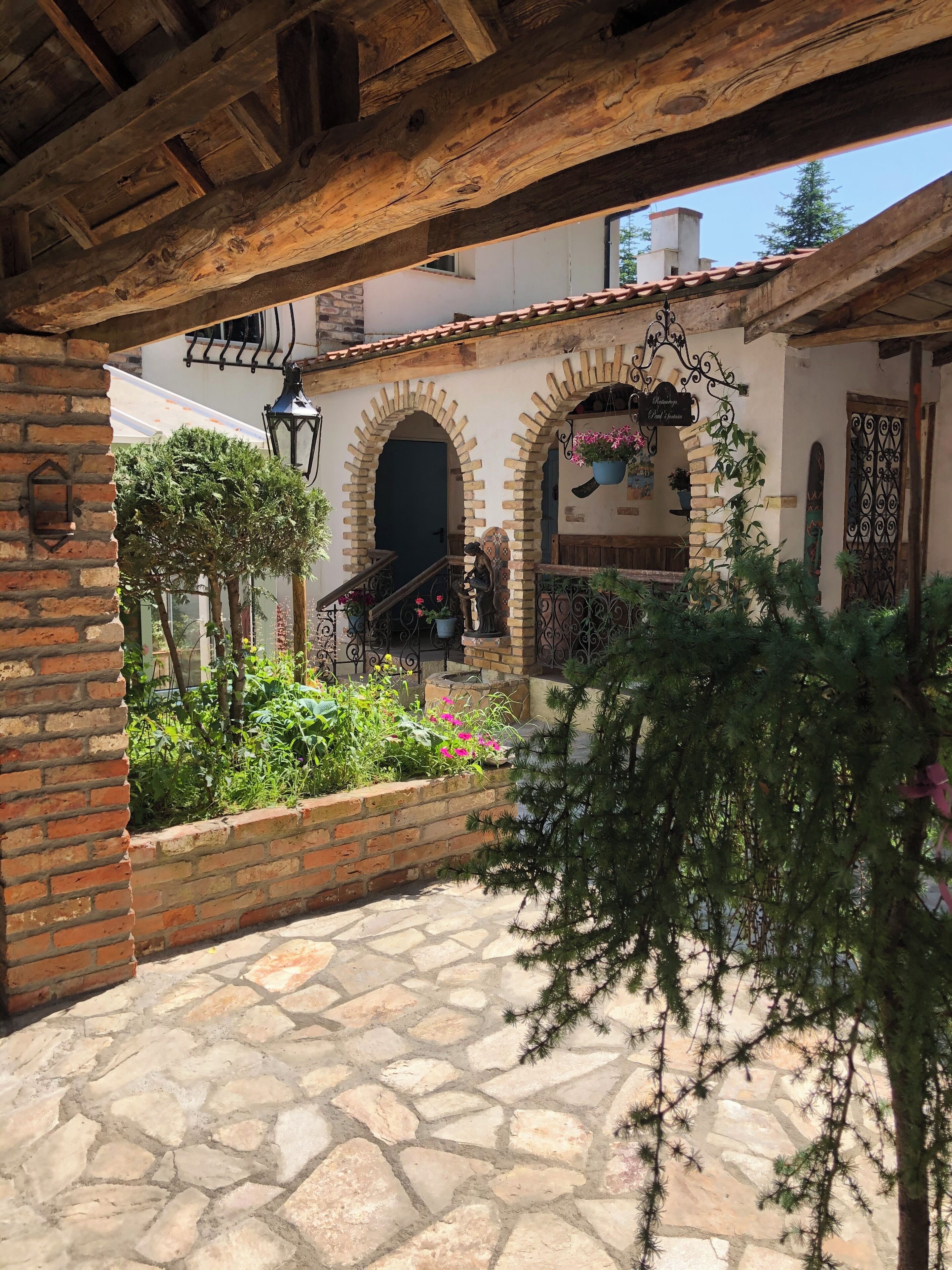 Ein Innenhof mit Steinpflasterung, Ziegelmauern und rundbogigen Durchgängen.